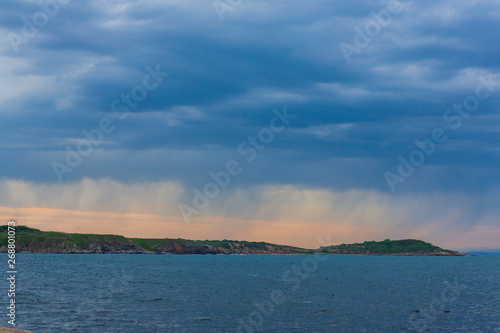 a marine landscape in the blue hour and a storm on the horizon. sea scenery and dramatic clouds. setting sun rising on the horizon.