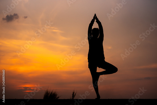 Silhouette Asia woman yoga on sunset. - Image