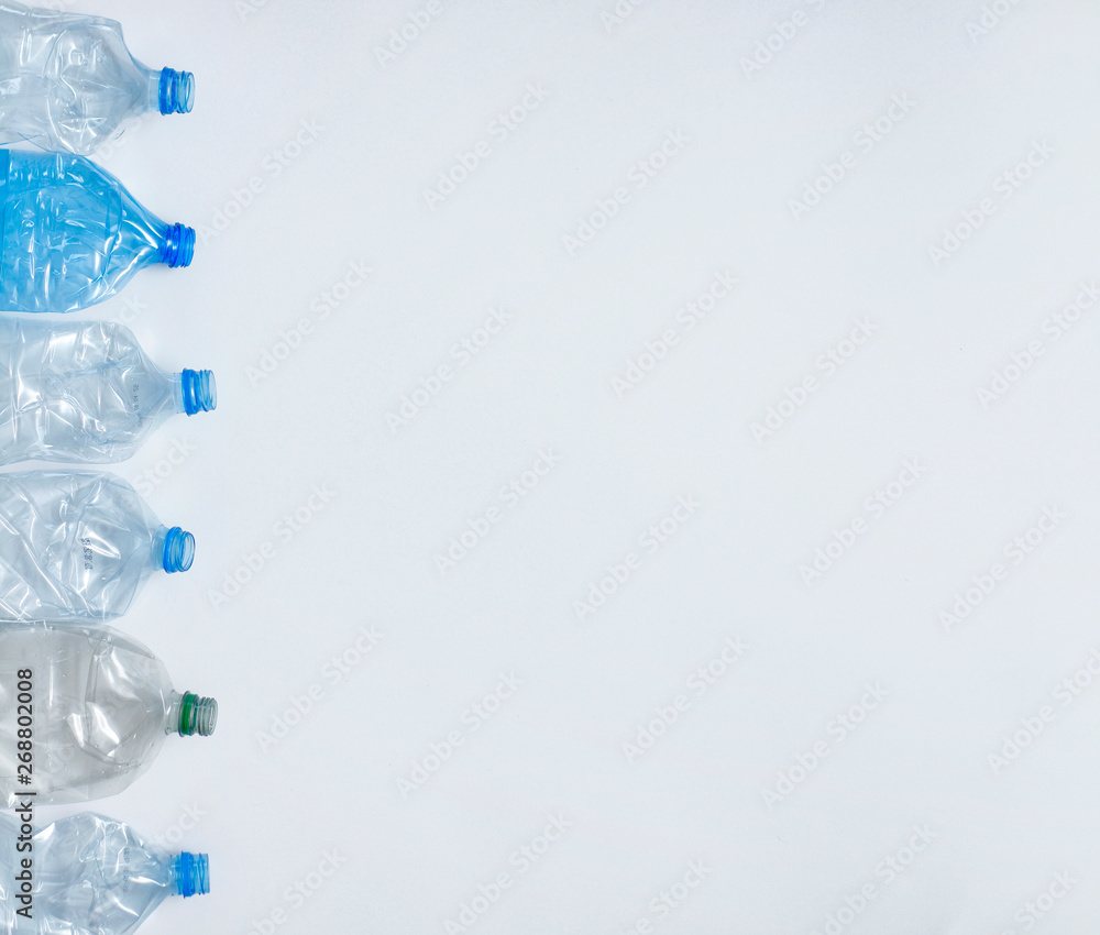 Plastic empty bottles on white background. View from above. Waste recycling concept. Your text place. Plastic empty bottles on white background. View from above. Waste recycling concept. Your text place.
