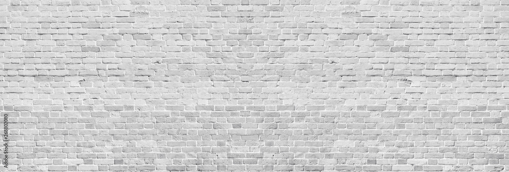 Fototapeta premium Szeroka biała umyta tekstura ściany z cegły. Szorstki, jasnoszary cegła vintage. Tło panoramiczne bielone