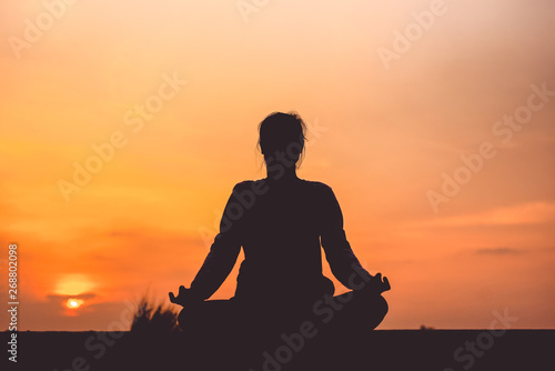 YOGA Silhouette woman sitting area meditating in sunset - Image