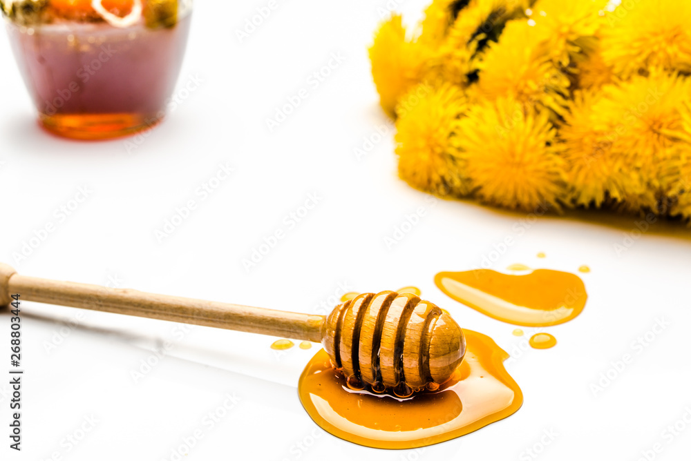 Dandelion flowers, honey dipper and glass jar of honey isolated on white background Dandelion flowers, honey dipper and glass jar of honey isolated on white background