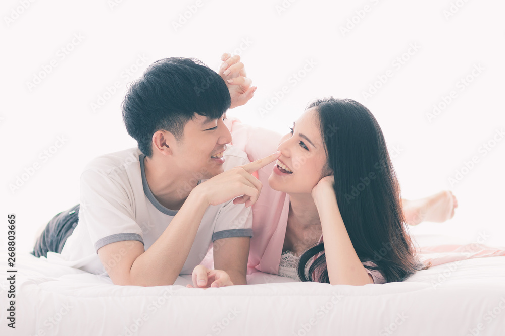 Asian couple spending time together on the bed.. Asian couple spending time together on the bed..
