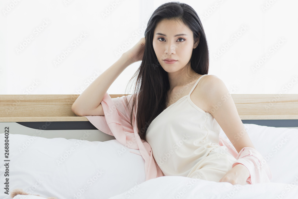 Asian woman model sitting and posing on bed.. Asian woman model sitting and posing on bed..
