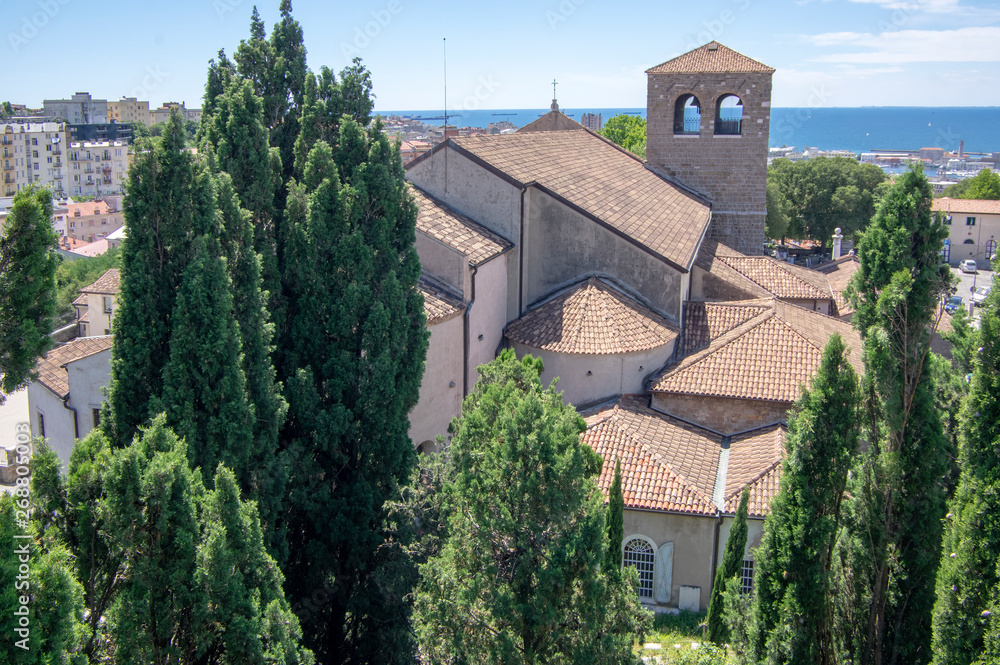 Obraz premium Trieste Cathedral next the Castello di San Giusto during touristic season.
