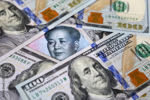 Wallpaper Mural Chinese yuan surrounded by US dollar bills. Concept of trade war between China and USA, economic sanctions, trading and investment Torontodigital.ca