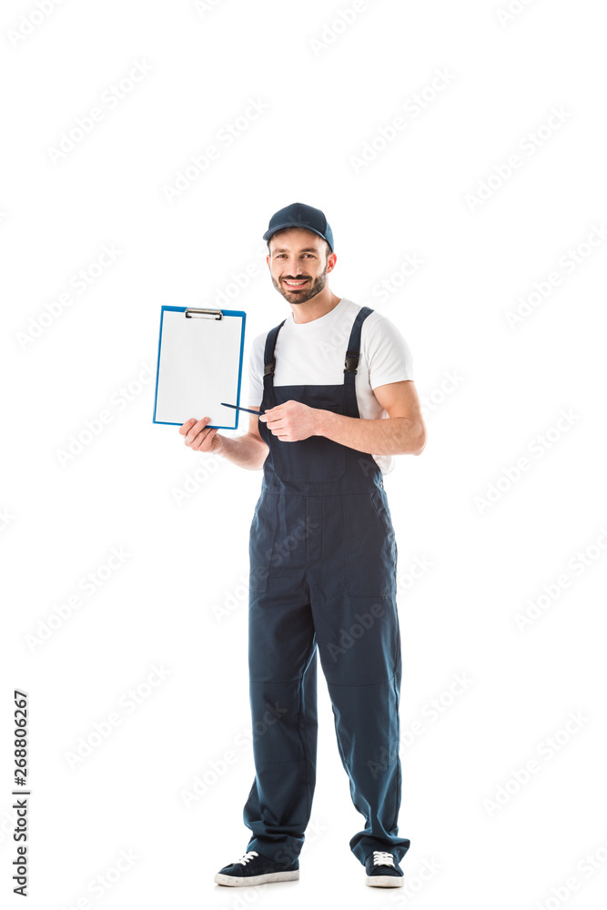 cheerful delivery man pointing with pen at clipboard with empty paper and looking at camera isolated on white cheerful delivery man pointing with pen at clipboard with empty paper and looking at camera isolated on white