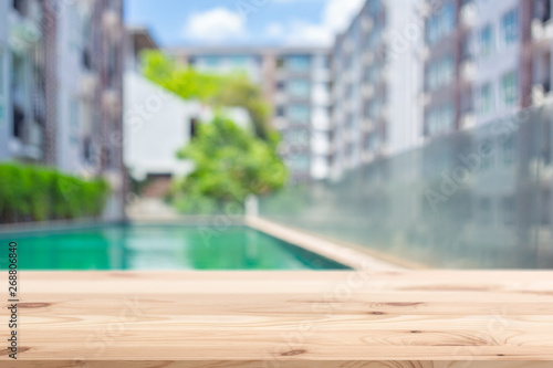 Wooden Table top with Condominium Accommodation blur background for advertising template