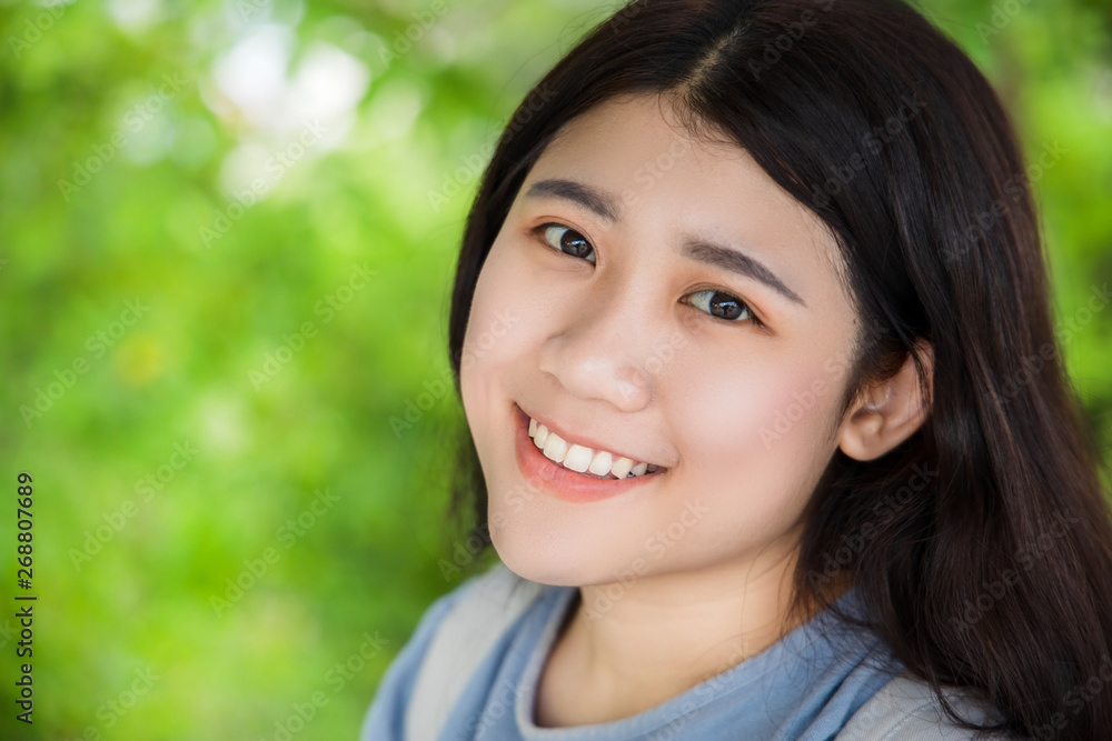 cute Asian healthy plump teen girl smile wth beautiful blur green nature background