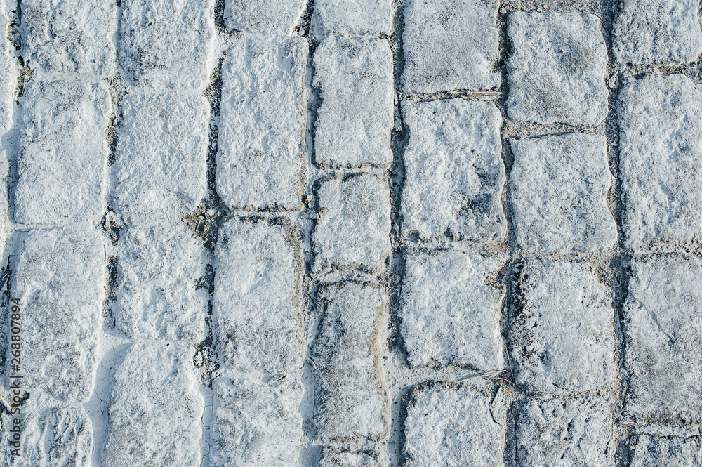 Obraz premium Close-up road aving slabs by mosaic construction. White paving cobbles.
