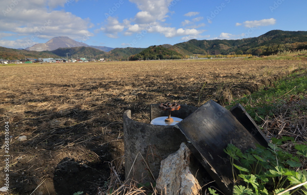 Obraz premium 畑に水を引くバルブと滋賀県の名峰、伊吹山が見える田園風景