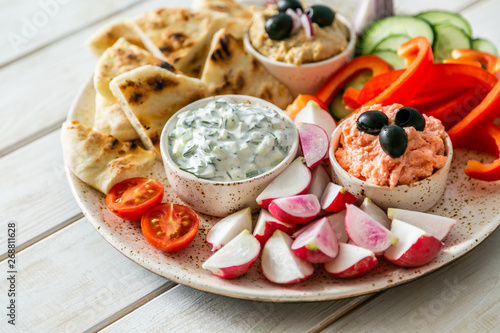 Selection of traditional greek food - salad, meze, pie, fish, tzatziki, dolma on wood background, top view