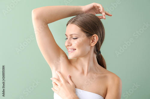 Beautiful young woman after laser hair removal procedure on color background