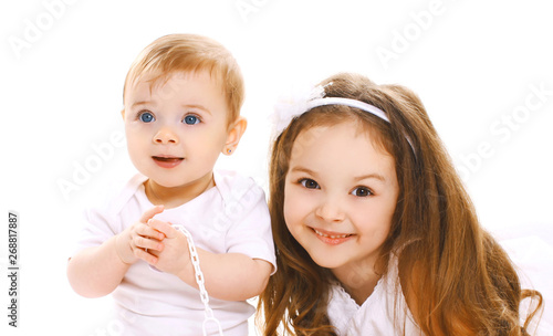 Portrait close-up happy smiling two children, older and younger sister isolated on white background