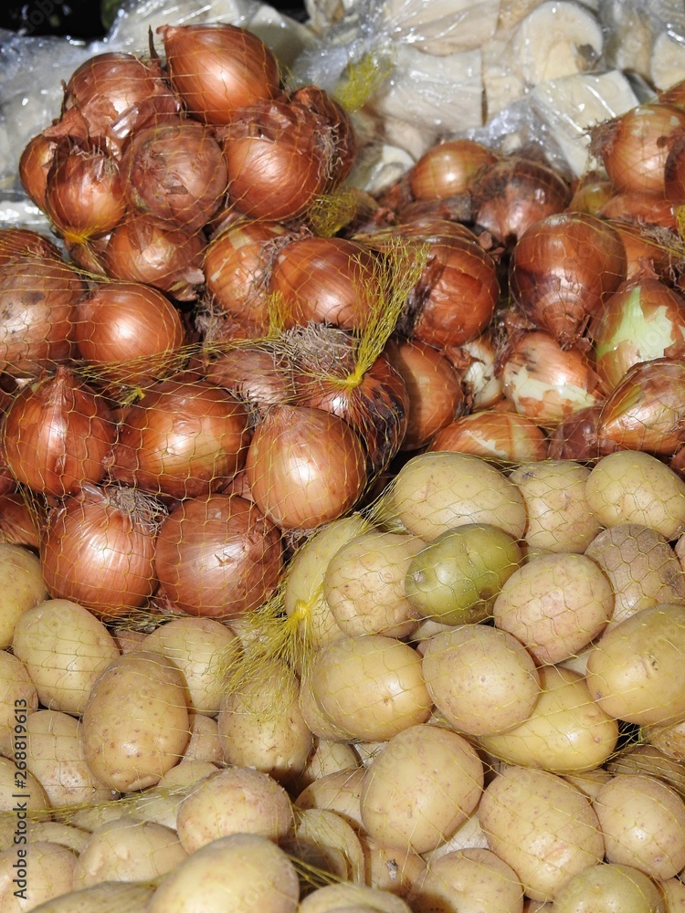 Sacks of onions and potatoes, displayed for sale in a market. Organic and healthy food. Sacks of onions and potatoes, displayed for sale in a market. Organic and healthy food.
