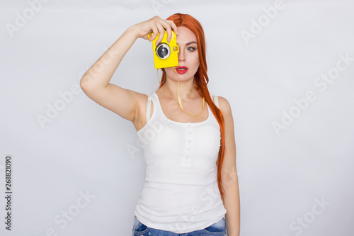 Redhead woman making photot and looking at yellow camera