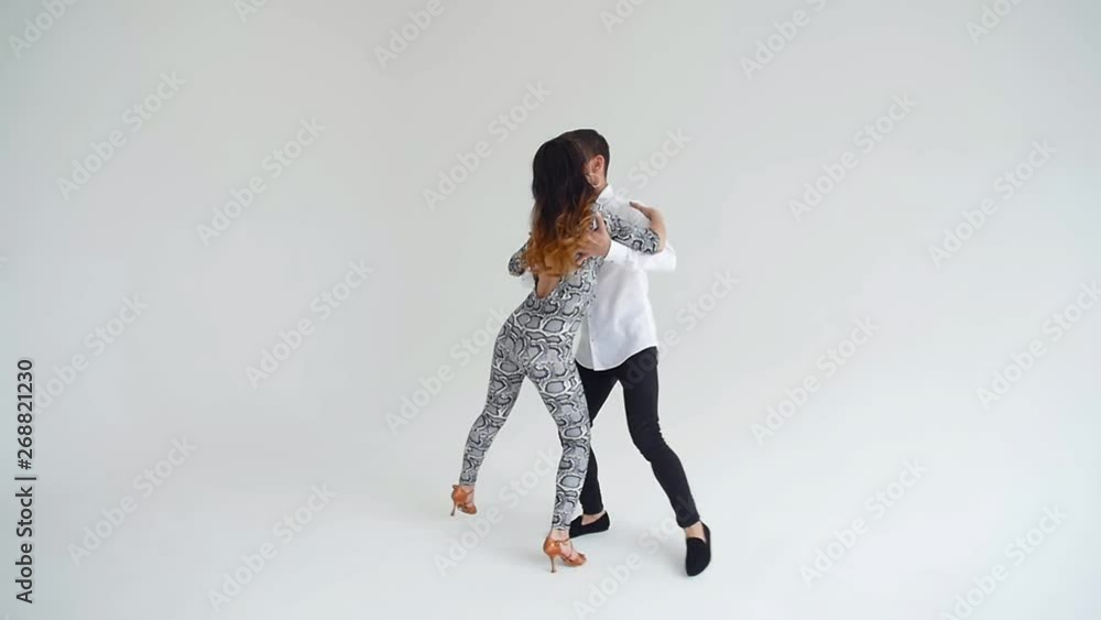 Concept of love, relationships and social dancing. Young beautiful couple dancing sensual dance on a white background Concept of love, relationships and social dancing. Young beautiful couple dancing sensual dance on a white background