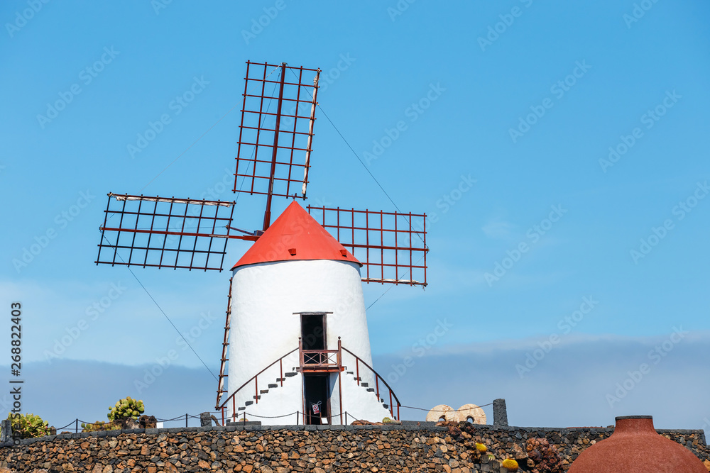 Windmill on blue sky background in cactus garden, Guatiza village, Lanzarote, Canary islands - obrazy, fototapety, plakaty 