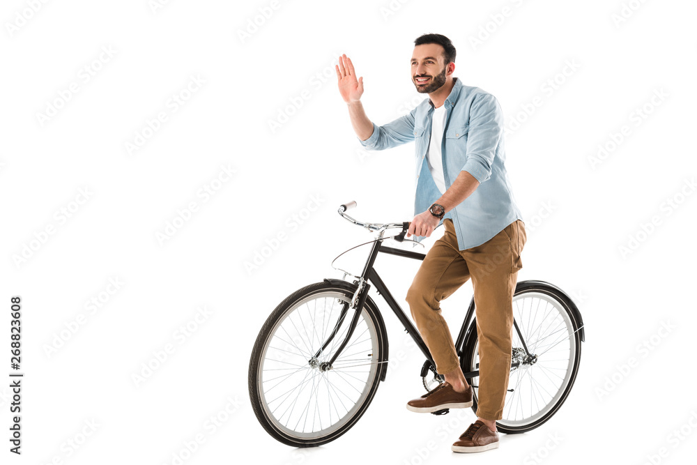 cheerful man with bicycle showing hello gesture and looking away isolated on white cheerful man with bicycle showing hello gesture and looking away isolated on white