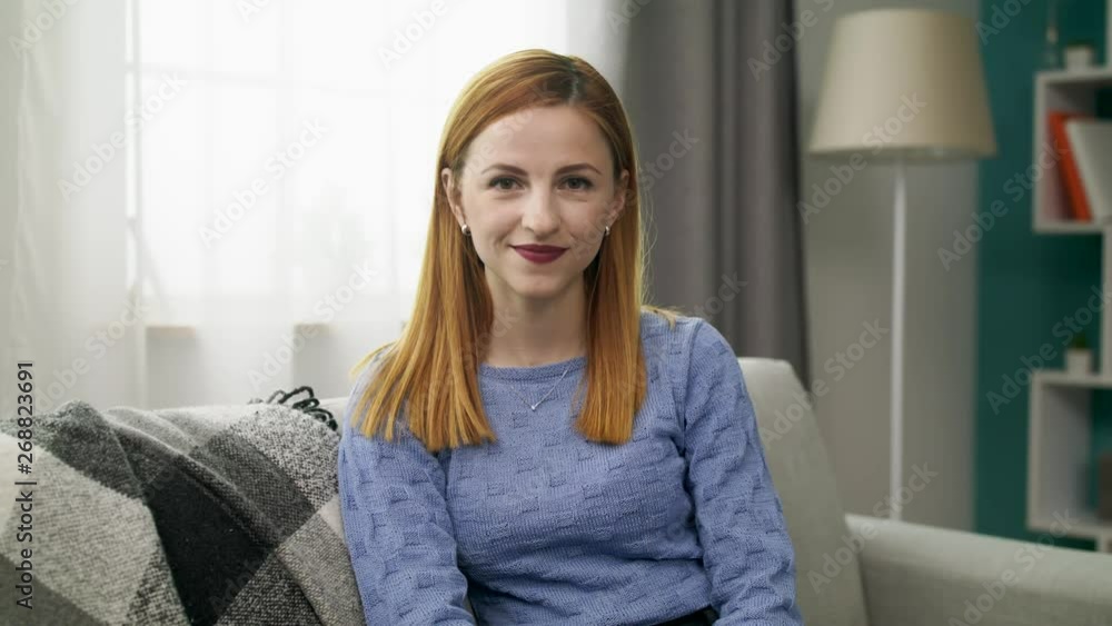 Portrait of a young cheerful girl in her cozy living room Portrait of a young cheerful girl in her cozy living room