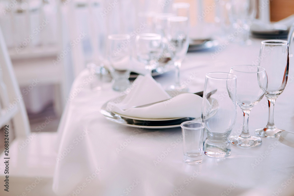 Fototapeta premium four Empty champagne and wine glasses on the white banquet table