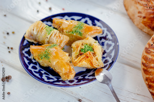 Asian dessert baklava or pahlava on a traditional oriental plate. photo