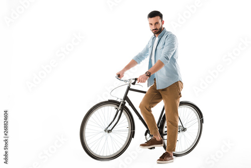 serious bearded man with bicycle looking at camera isolated on white