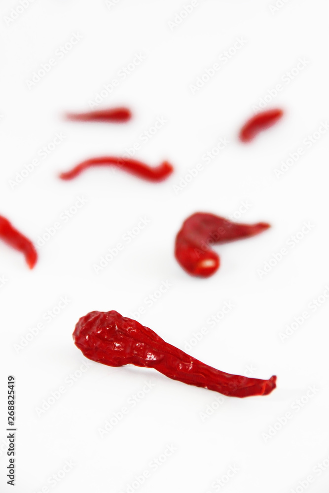 pods of red dried hot bitter edible pepper on a white background pods of red dried hot bitter edible pepper on a white background