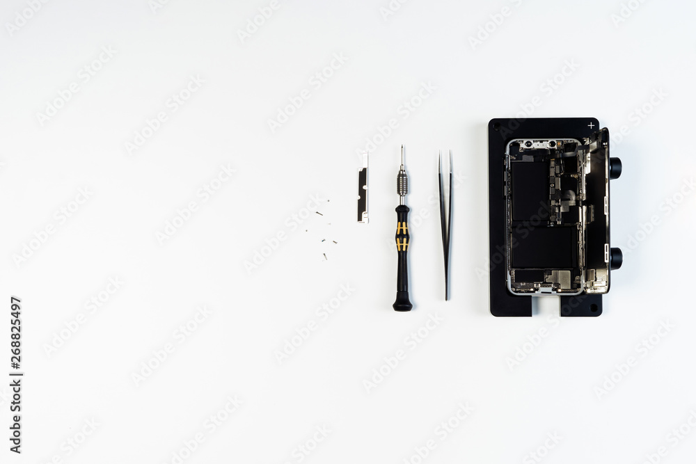 Disassembled Open Mobile Phone Screwdriver Tool Above Flat Lay Isolated on White Background. Dismantle Smartphone. Cellphone Holder Overhead. Telephone Fix Fix Service Overhead Disassembled Open Mobile Phone Screwdriver Tool Above Flat Lay Isolated on White Background. Dismantle Smartphone. Cellphone Holder Overhead. Telephone Fix Fix Service Overhead