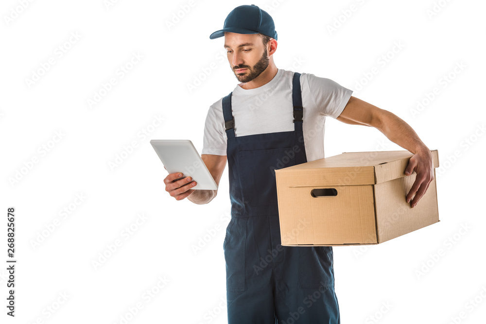 attentive delivery man using digital tablet while holding cardboard box isolated on white attentive delivery man using digital tablet while holding cardboard box isolated on white
