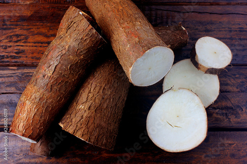 Organic cassava (mandioca, aipim, brazilian cuisine), fresh and raw on rustic wooden table photo