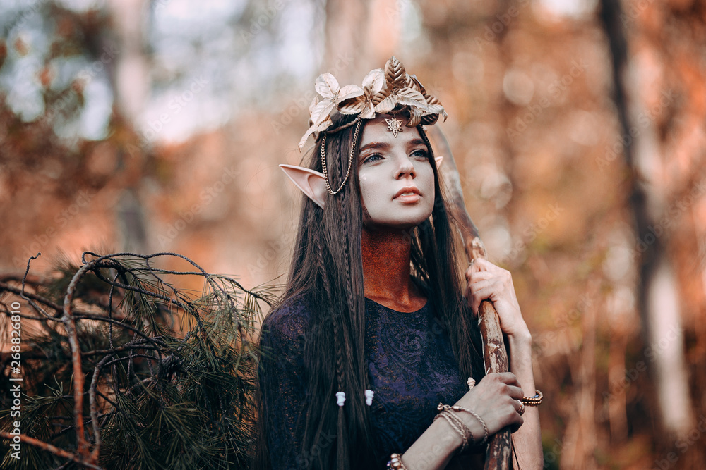 Naklejka premium beautiful elf woman fabulous, fairy forest, famtasy young woman with long ears, long dark hair golden wreath crown on head
