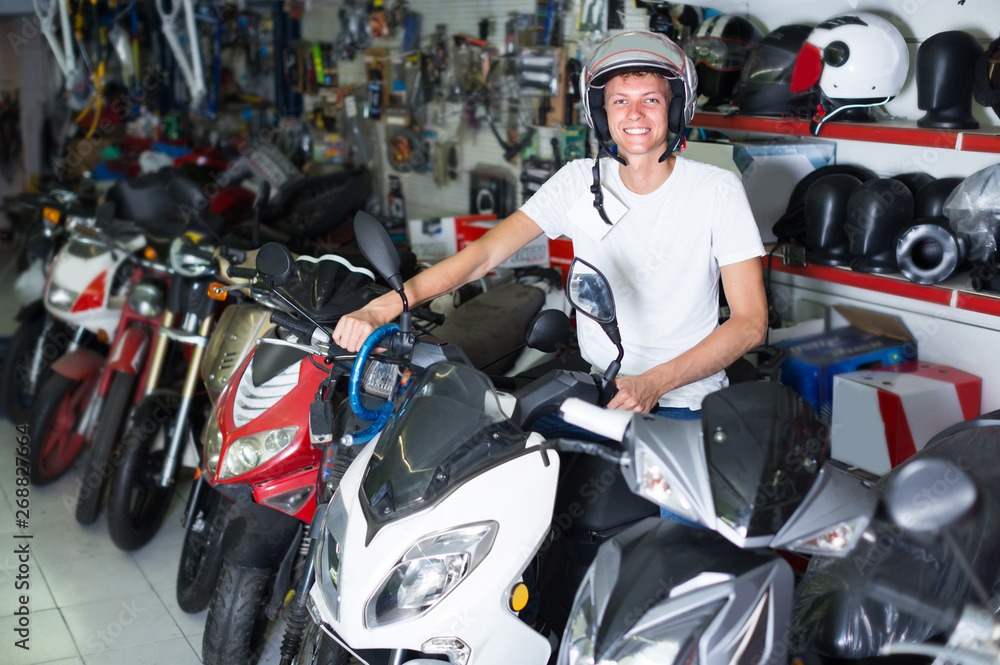 Adult man in helmet is sitting on motorbike