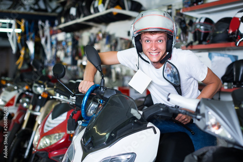 Young man in helmet is sitting on motorbike