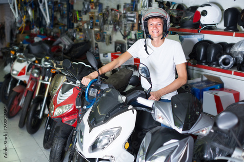 Adult man in helmet is sitting on motorbike