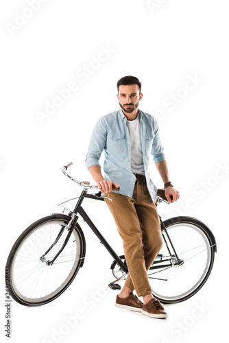 serous bearded man with bicycle looking at camera isolated on white