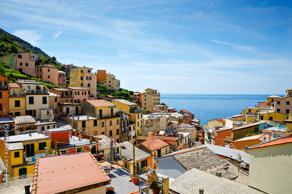 Riomaggiore, Liguria, Italy fisherman village, colorful houses on sunny warm day. Monterosso al Mare, Vernazza, Corniglia, Manarola, and Riomaggiore, Cinque Terre National Park UNESCO World Heritage