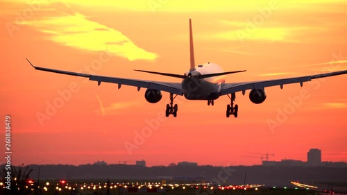 Airplane landing at sunset