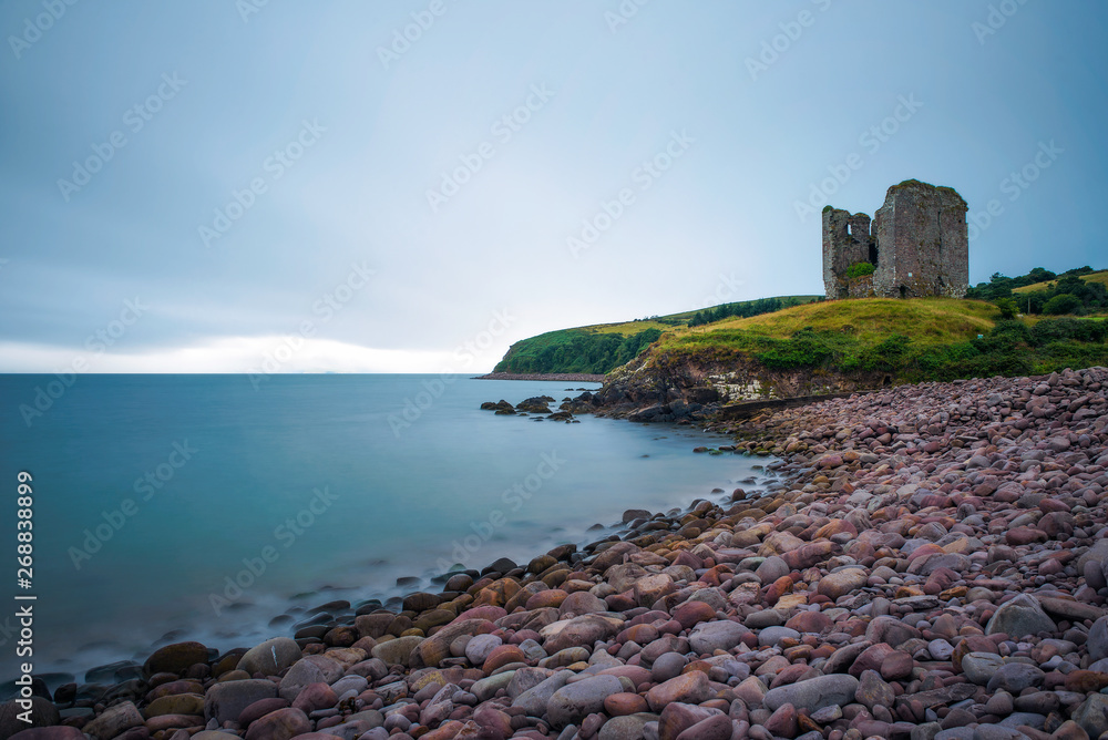 Stone beach and the Minard Castle situated on the Dingle Peninsula in Ireland