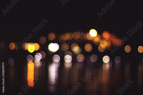 beautiful Night light with bokeh blurred on river and reflex in water colorful celebrate background