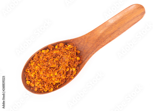 Top view red chilli power in wood spoon on white background, food ingredient