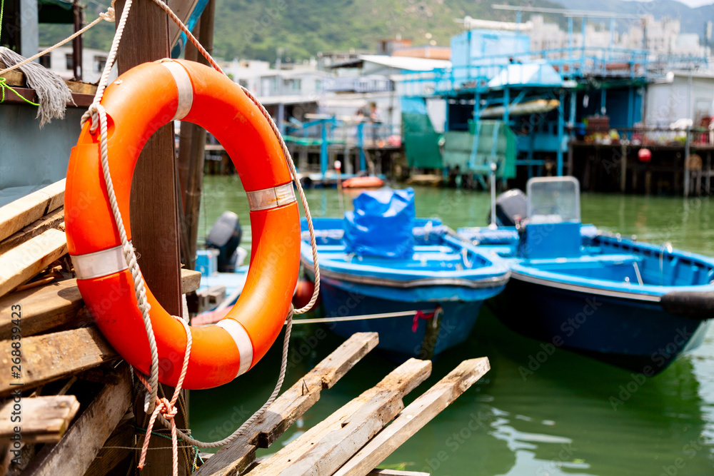 Lifebuoy and fishing boats in fishing village Tai O in Lantau island, Hong Kong