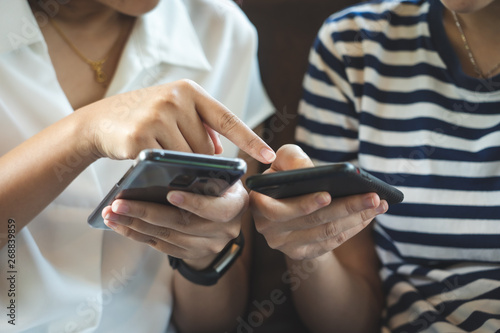 A beautiful Asian woman uses a smartphone in the city center to search for various places. Restaurant reviews And send a message with copy space.