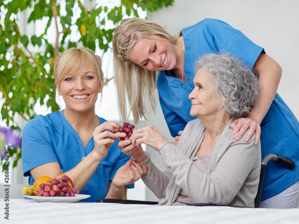Seniorin mit Pflegerinnen Seniorin mit Pflegerinnen