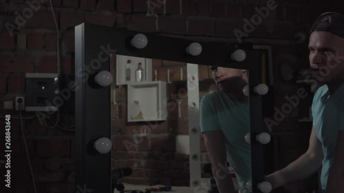 Carpenter checking mirror with lights if its work or not work. Hand manufacturing. Craftman works in a workshop. photo