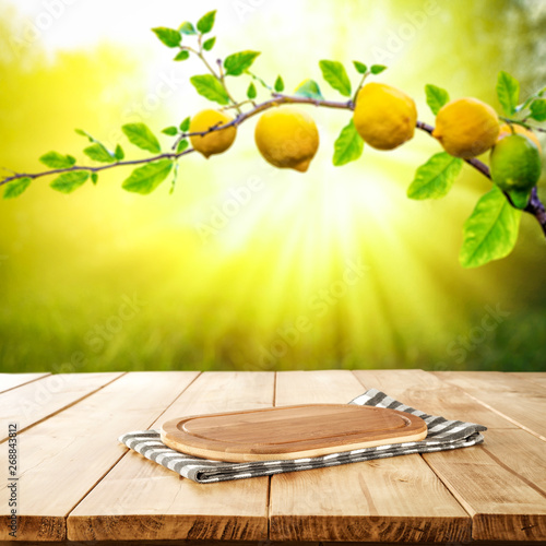 Table background of free space and summer garden background. Branch of fresh lemons and summser sunny day. 