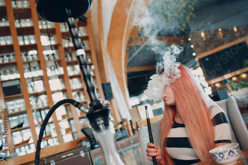 Fototapeta Naklejka Na Ścianę i Meble -  Young beautiful female smoking hookah. Smoke shisha hookah concept.