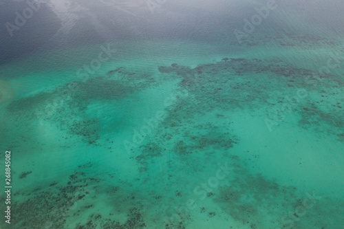 Aerial drone top view of the crystal clear lagoon sea water surface with coral reef