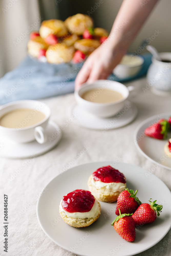 Devonshire style afternoon tea with cream then jam with woman se Devonshire style afternoon tea with cream then jam with woman se