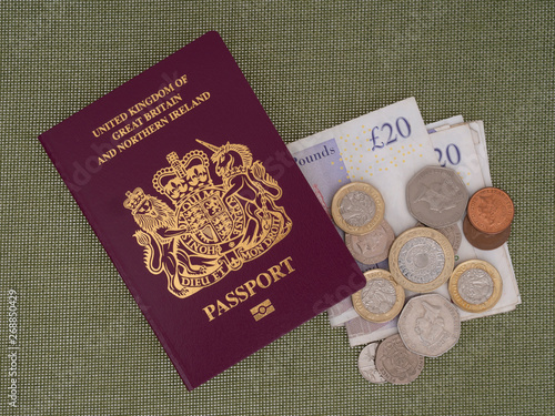 New Bergundy UK passport, no longer showing words 'European Union'. With currency, pounds sterling. On cloth background. photo